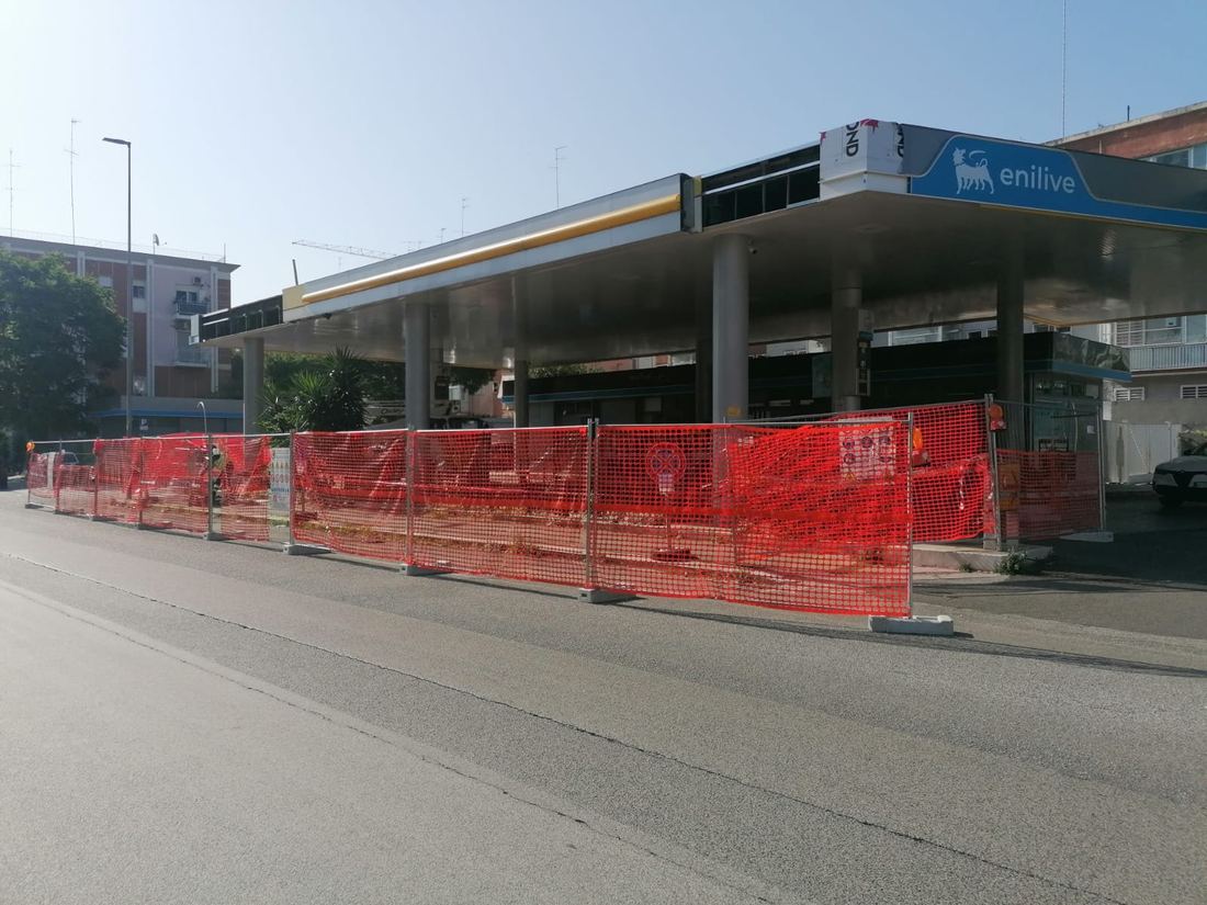Pensilina Enilive con cantiere recintato lungo la strada