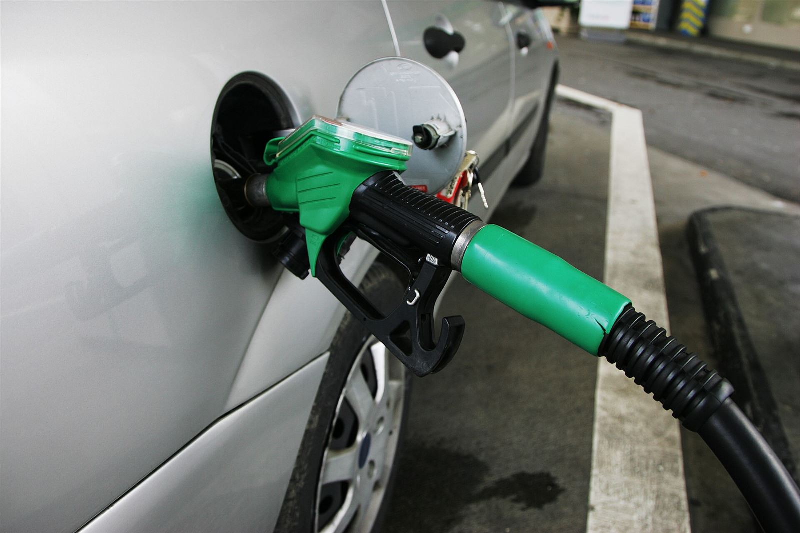 Pistola erogatrice verde inserita nel bocchettone di un'auto